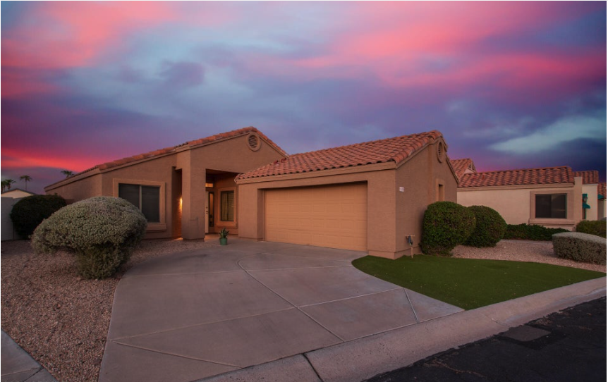 Stunning modern home in Peoria, Arizona with stone accents, desert landscaping, and sunset backdrop"